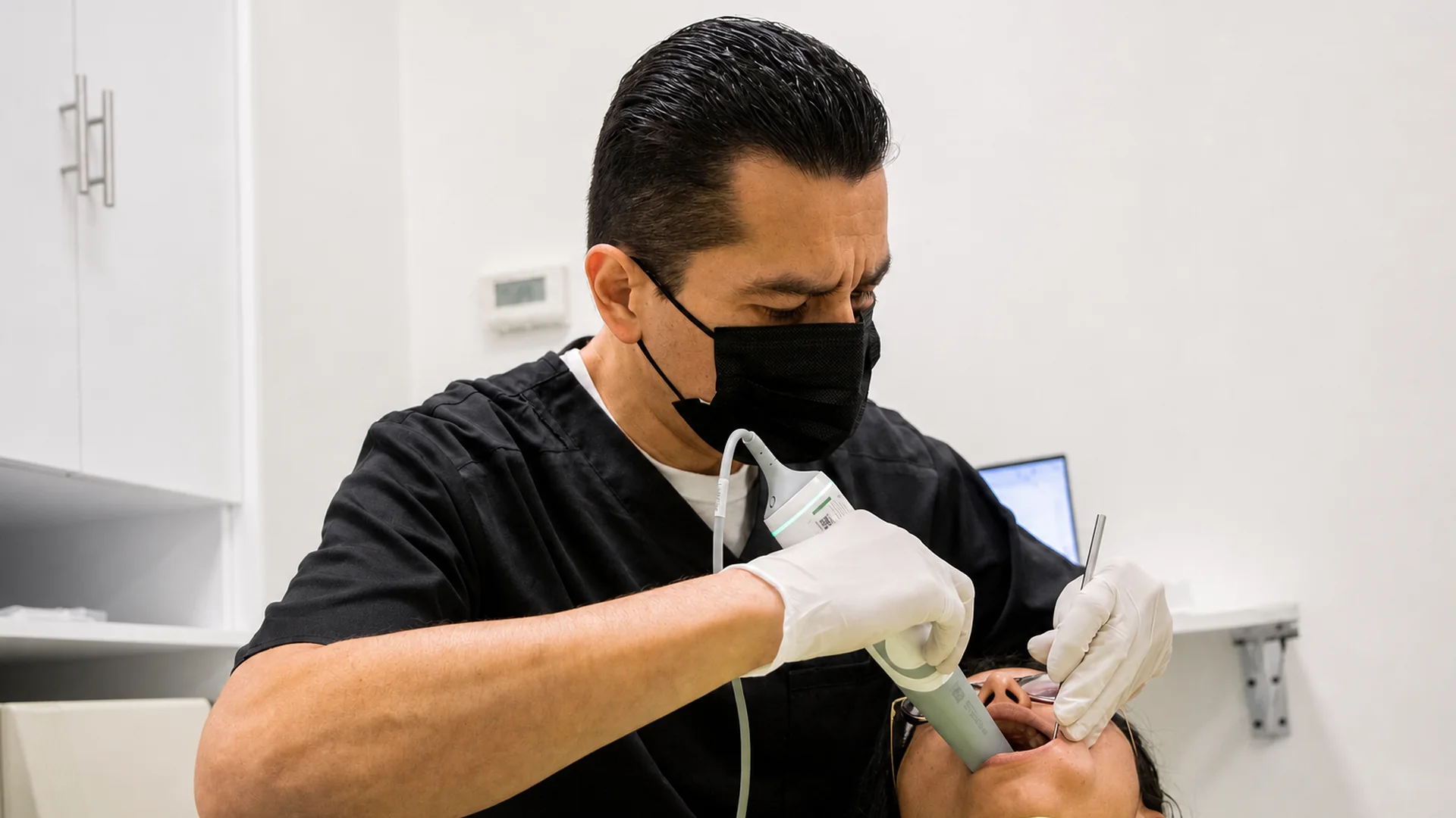 Dr. Israel Ramos performing an intraoral scan during a clinical appointment.