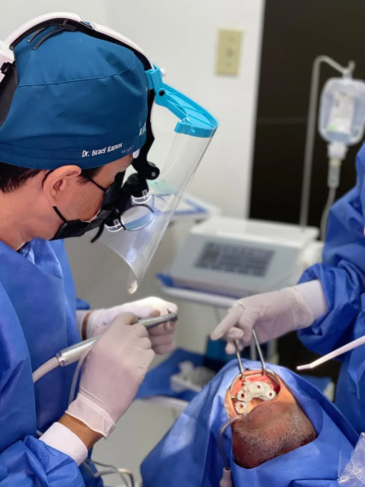Dr. Israel Ramos performing implant surgery with his clinical team.